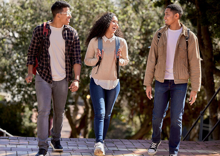Three students walking together and engaged in conversation