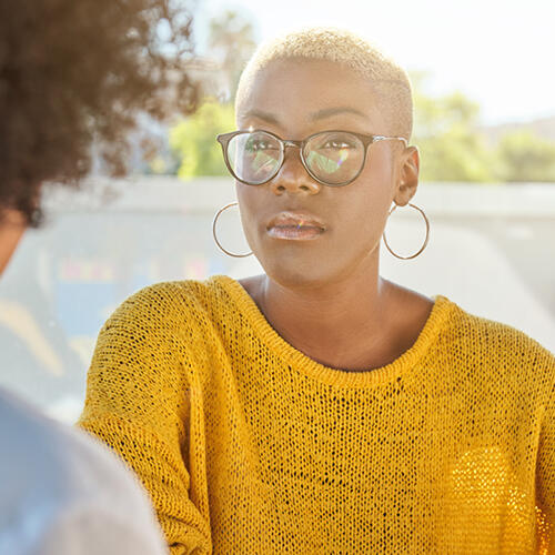 Female with glasses wearing a yellow sweater