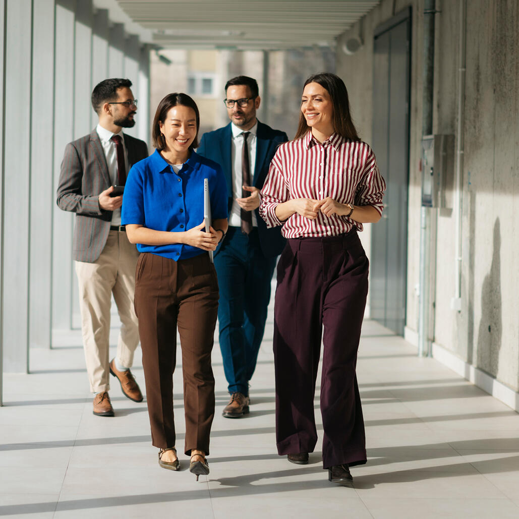 Business professionals walking through a modern office hallway.