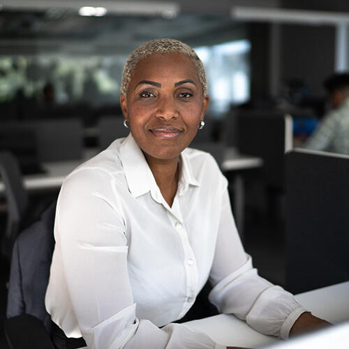 Licensed attorney sitting at a desk and looking at the camera
