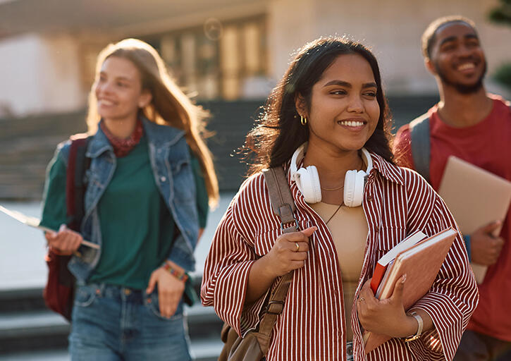 Three students walking on a college campus