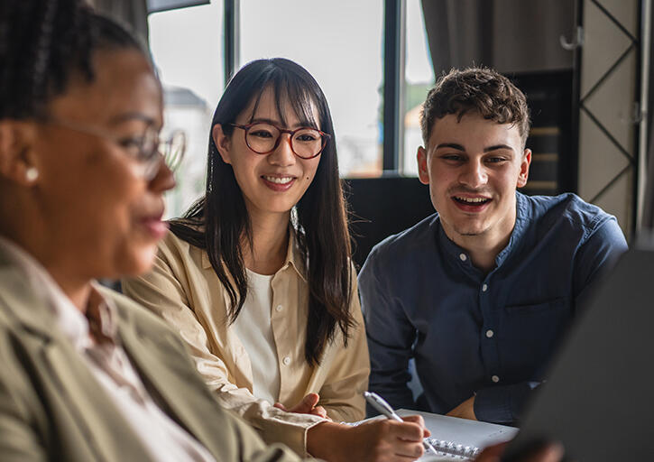 Law school professional supports two law students preparing to take the bar exam by showing bar prep resources on a tablet screen.