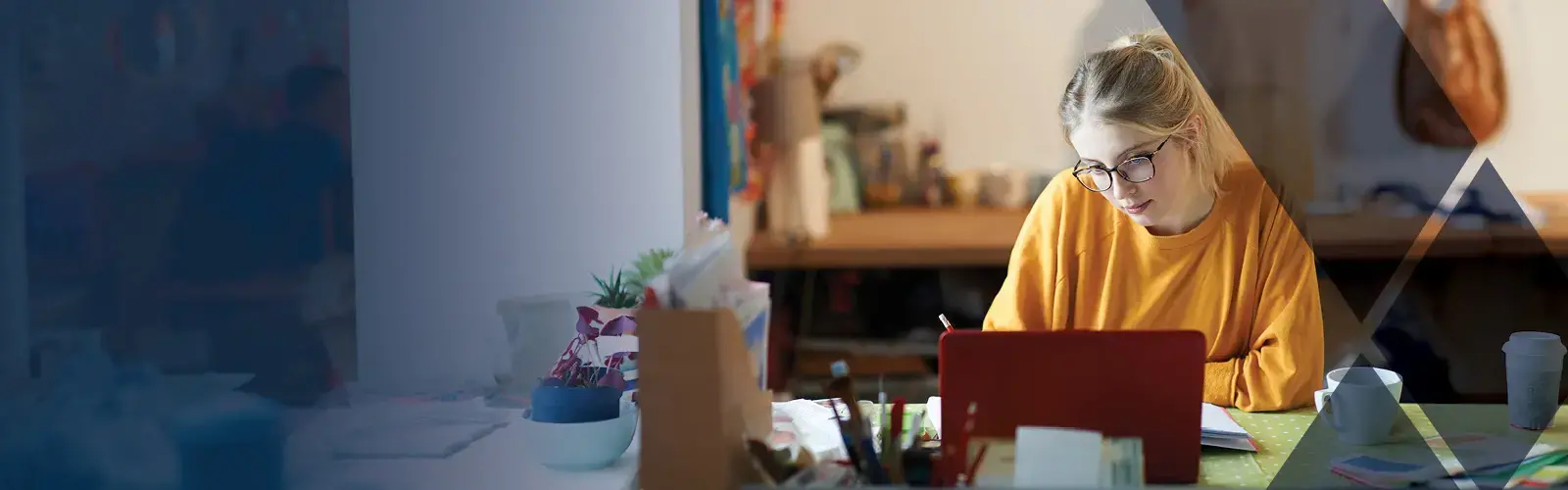 A student studying at a desk with laptop  