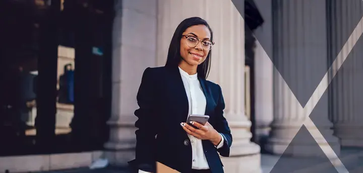 A young lawyer on the steps of a courthouse holding a mobile phone and folders. 
