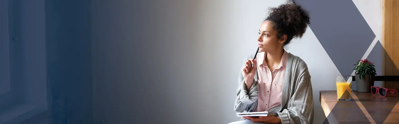 Young adult sitting at home with pen and paper 