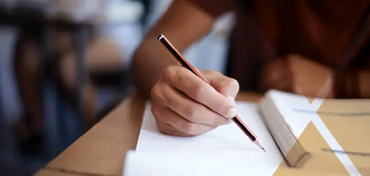 Hand holding a pencil to paper 