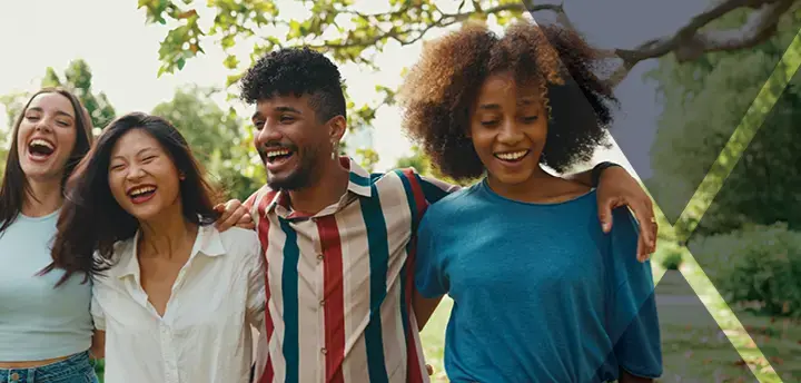 Happy multiethnic people walk embracing on summer day outdoors 
