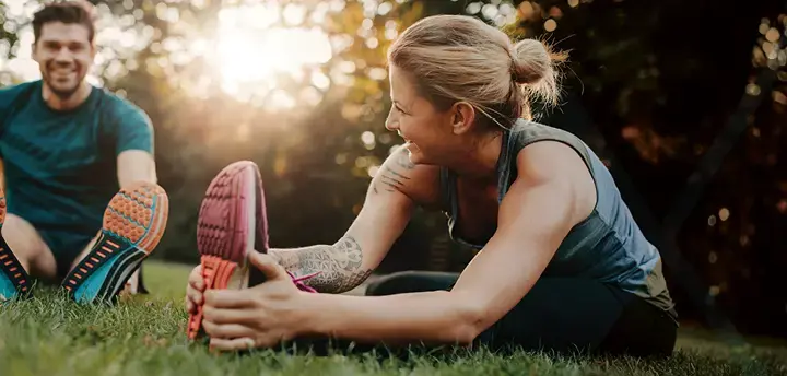 Young couple doing their stretches in the park 