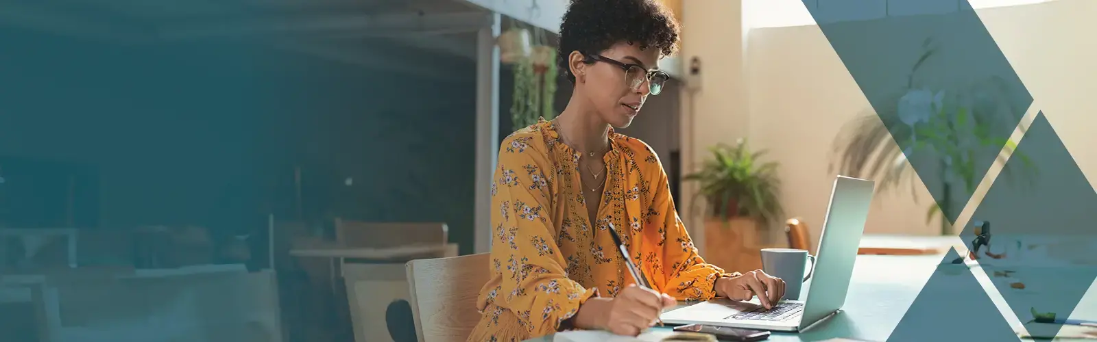 Professional working on laptop and taking notes. 
