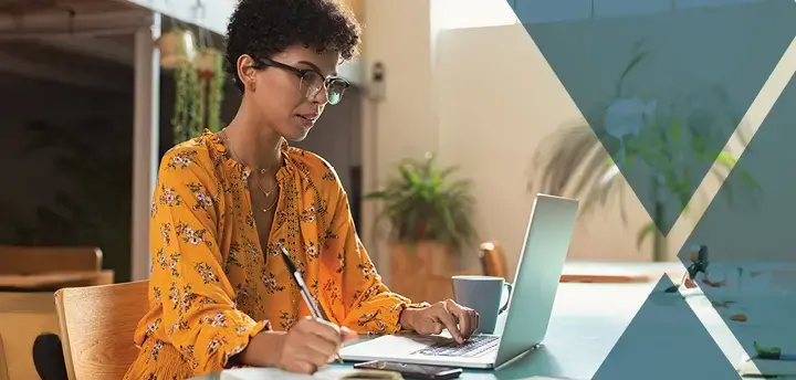 Professional working on laptop and taking notes. 