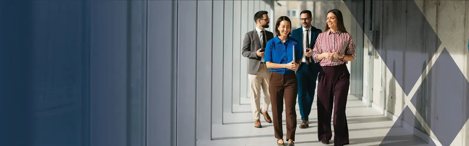 Business professionals walking through a modern office hallway.