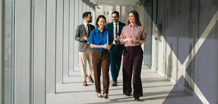 Business professionals walking through a modern office hallway.