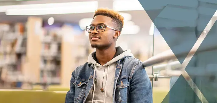 Law student sitting in a library looking off into the distance. 